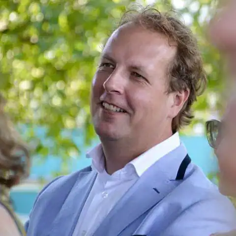Zacht licht op een man die glimlacht, symboliseert warmte en persoonlijke aandacht bij uitvaartverzorging in Nederland.