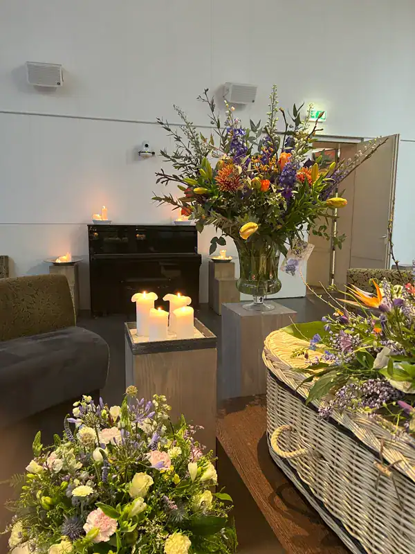 Rustige uitvaartlocatie met bloemen en kaarsen, verzorgd door De Dageraad Uitvaartverzorging, bieden een serene ambiente voor afscheid en troost.