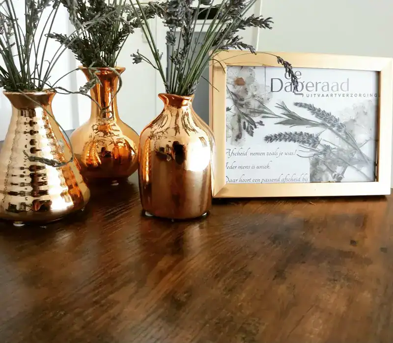 Roestvrijstalen bloemen vazen en een grafframe met bloemmotief bij De Dageraad Uitvaartverzorging.