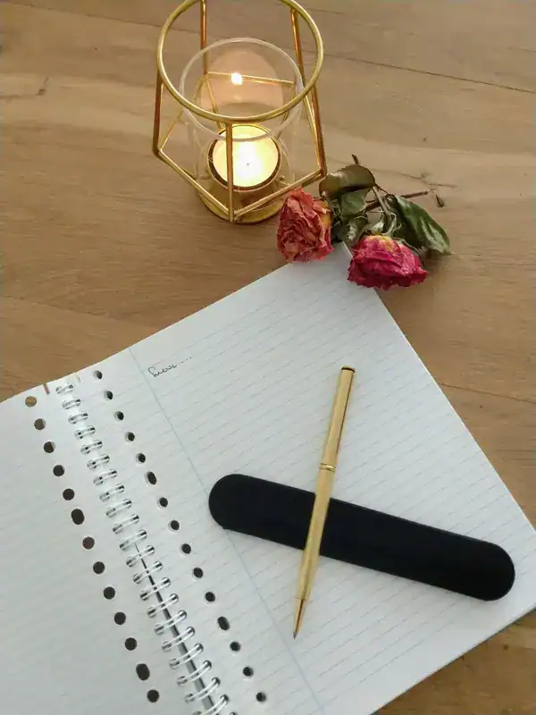Kaligrafie pen en gedichtenpapier bij uitvaartverzorging De Dageraad, symboliseert herinneringen en afscheid nemen.