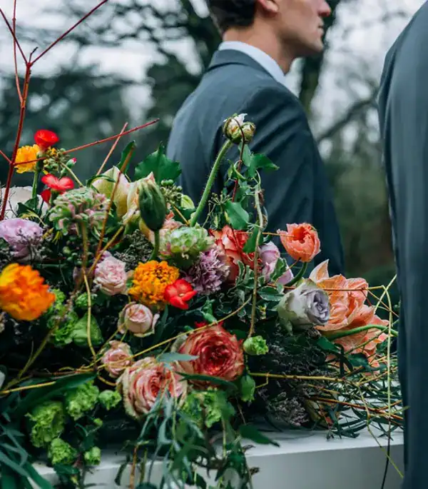 Roze en oranje bloemen uitvaart, bloemstuk voor een uitvaart, De Dageraad Uitvaartverzorging, rouwbloemen en begrafenisversiering, rouwbloemen op uitvaartdienst.